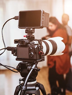 A video production company sets up a professional camera on a tripod in a room for video production.