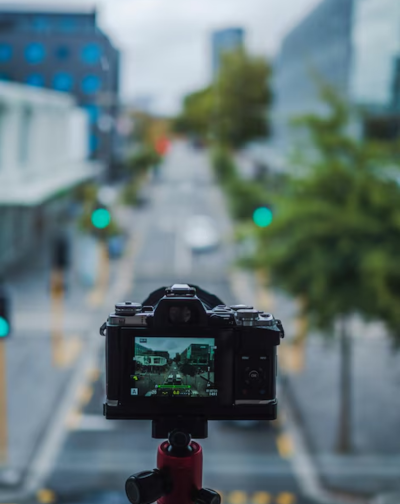 Best Documentary Flim Makers Companies in Erode, Coimbatore A man records footage of an entire sidewalk for film production using a tripod-mounted camera.