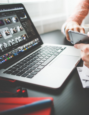 Best Video Production Services For Websites in Coimbatore A branding professional working on logo design services on a laptop and mobile device at the office