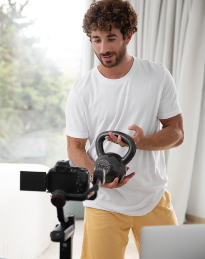 Top Efficient Promotional Video Production in Coimbatore The concept for a promotional film production with a man using an electronic device and a kettlebell